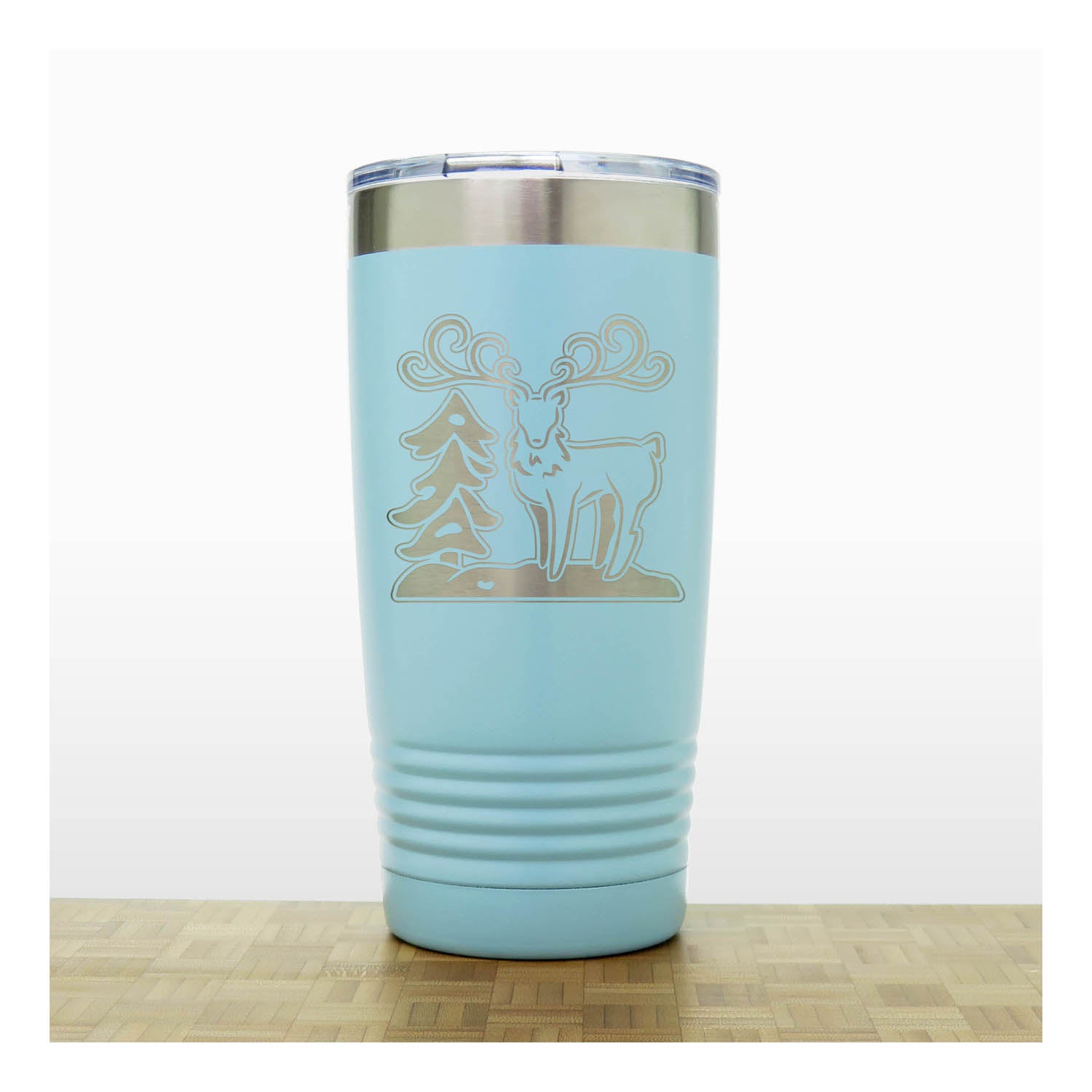 Teal - Insulated Travel Mug with the design of a Reindeer sta nding beside a Christmas tree - Copyright Hues in Glass