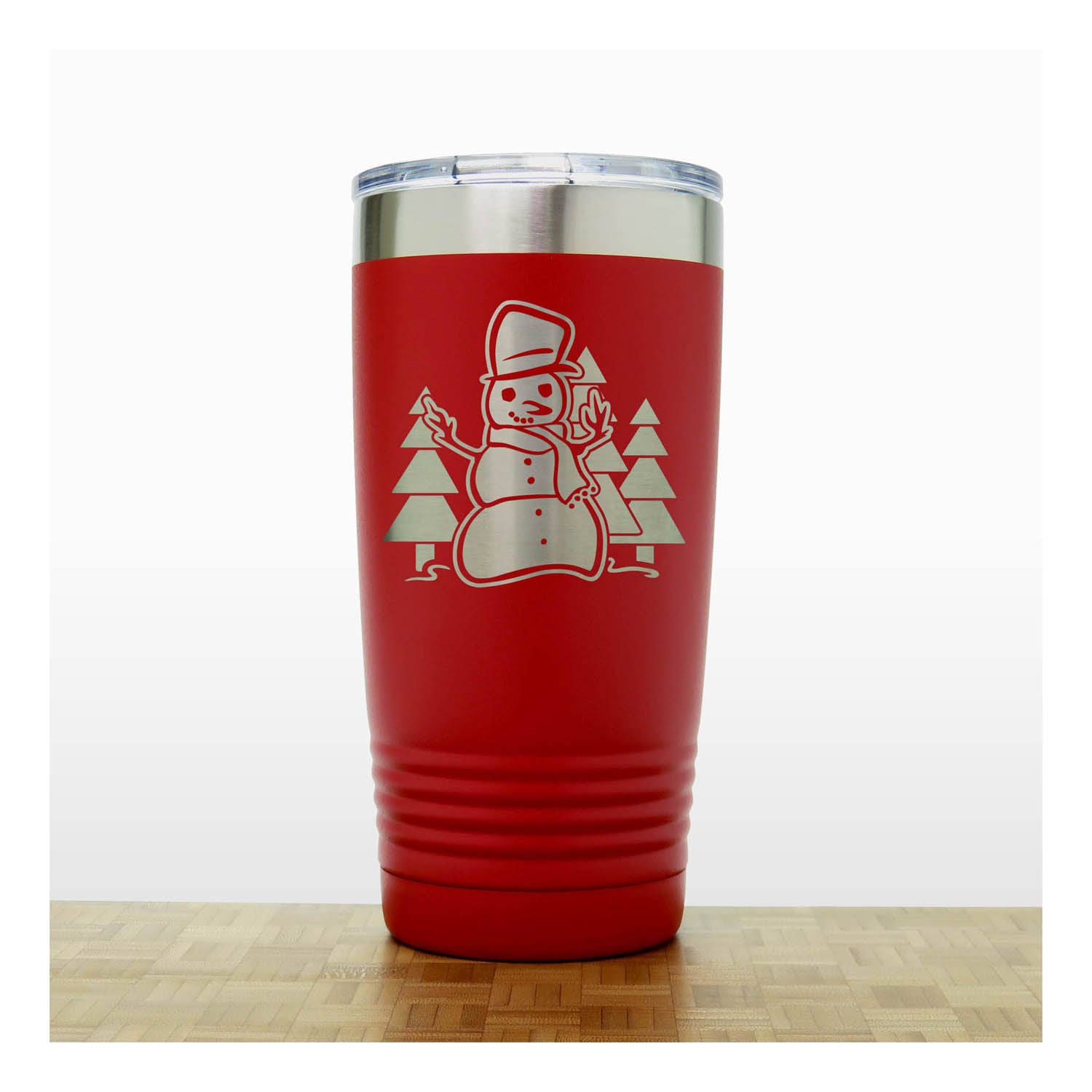 Red 20 oz Insulated Tumbler with the design of a snowman standing in front of Christmas trees - Copyright Hues in Glass