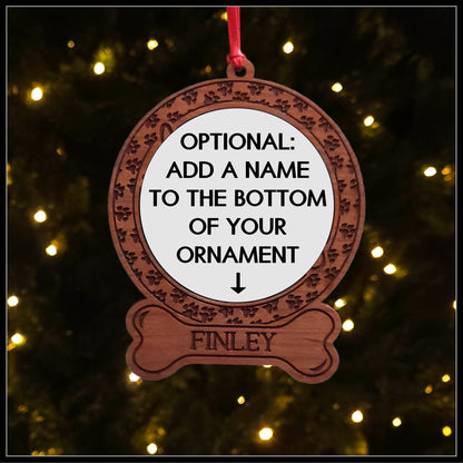 A round wood veneer ornament with a border of small paw prints, with writing indicating that a bone can be added below the border collie dog ornament.