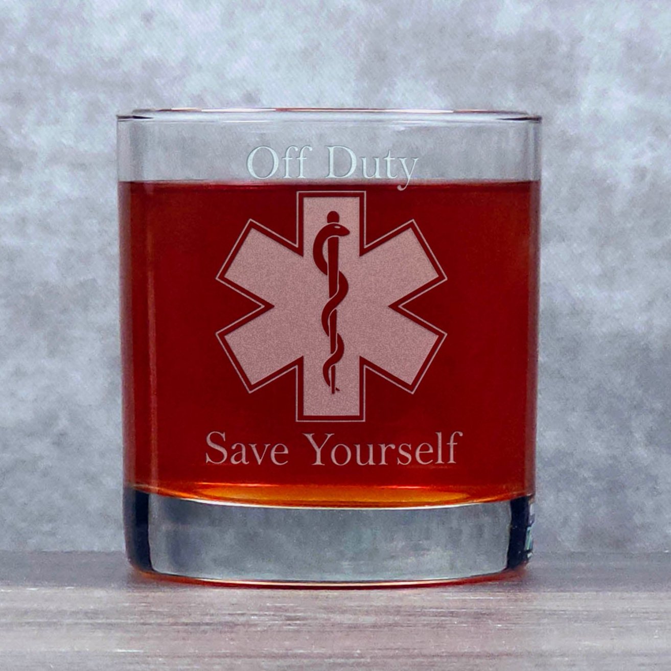  11oz whiskey glass with and image of the EMS Maltese Cross with the Rod of Asclepius in the middle, and the words Off Duty above and Save Yourself below the cross